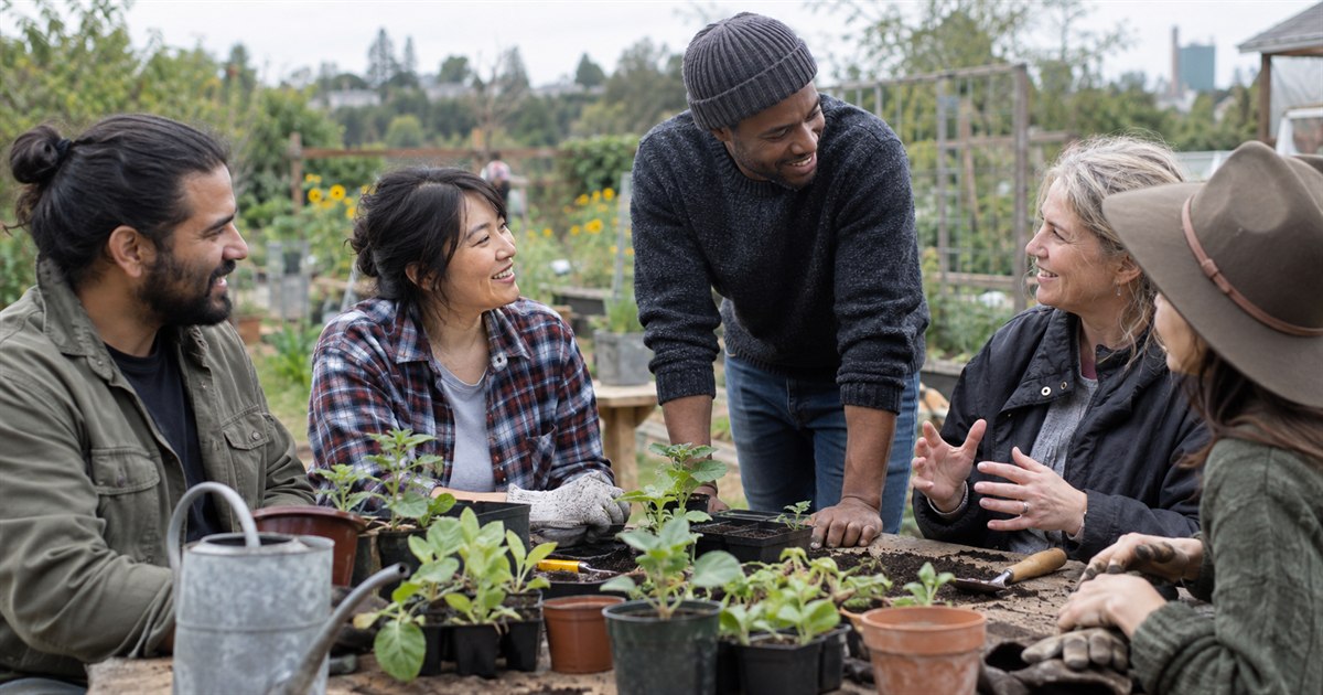 A diverse group of adults working together at a community garden table